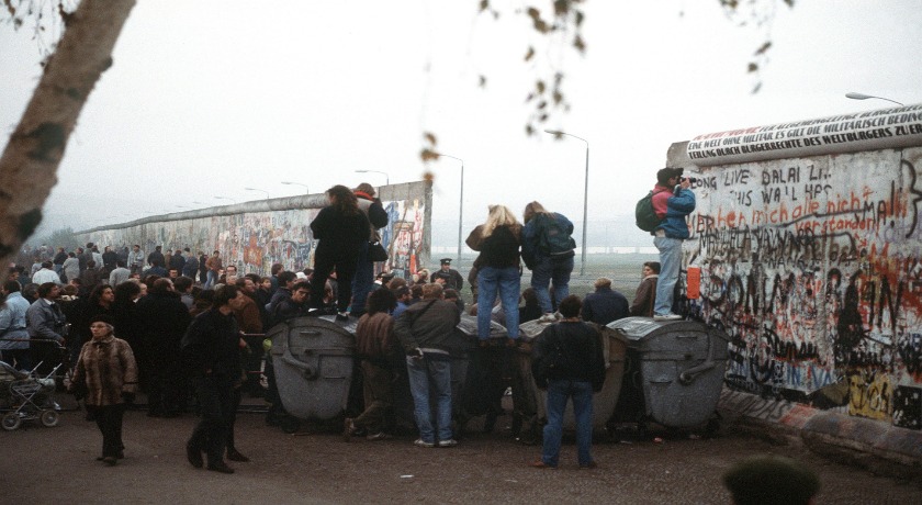 People gather at an opening made in the Berlin Wall credit US DoD