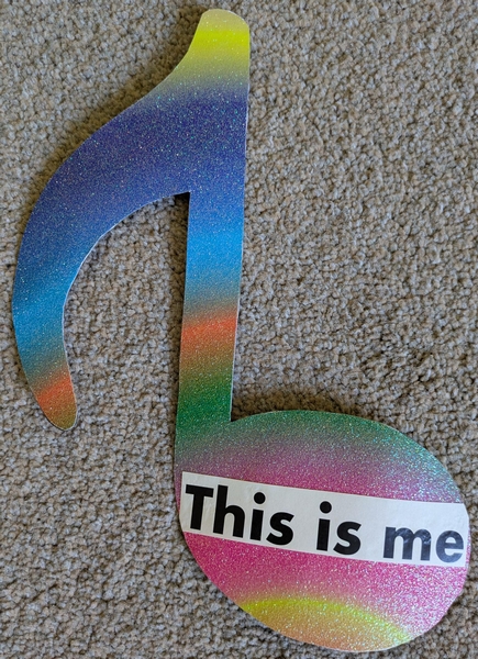 Cutout music note in sparkly, rainbow card with the text This is me