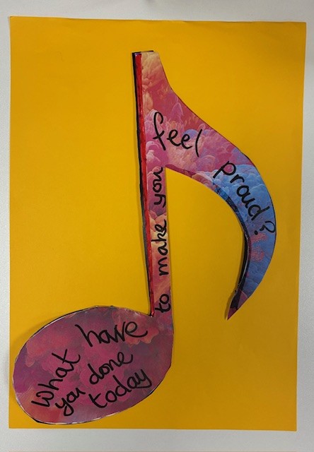 A music note made from paper. It is colourful and has a song lyrics written on it: What have you done today to make you feel proud?